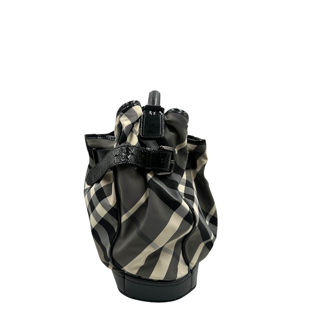 Vista laterale di una borsa Burberry in poliammide e acrilico trama tartan, con finiture nere lucide, usata, originale, second hand, in ottime condizioni.