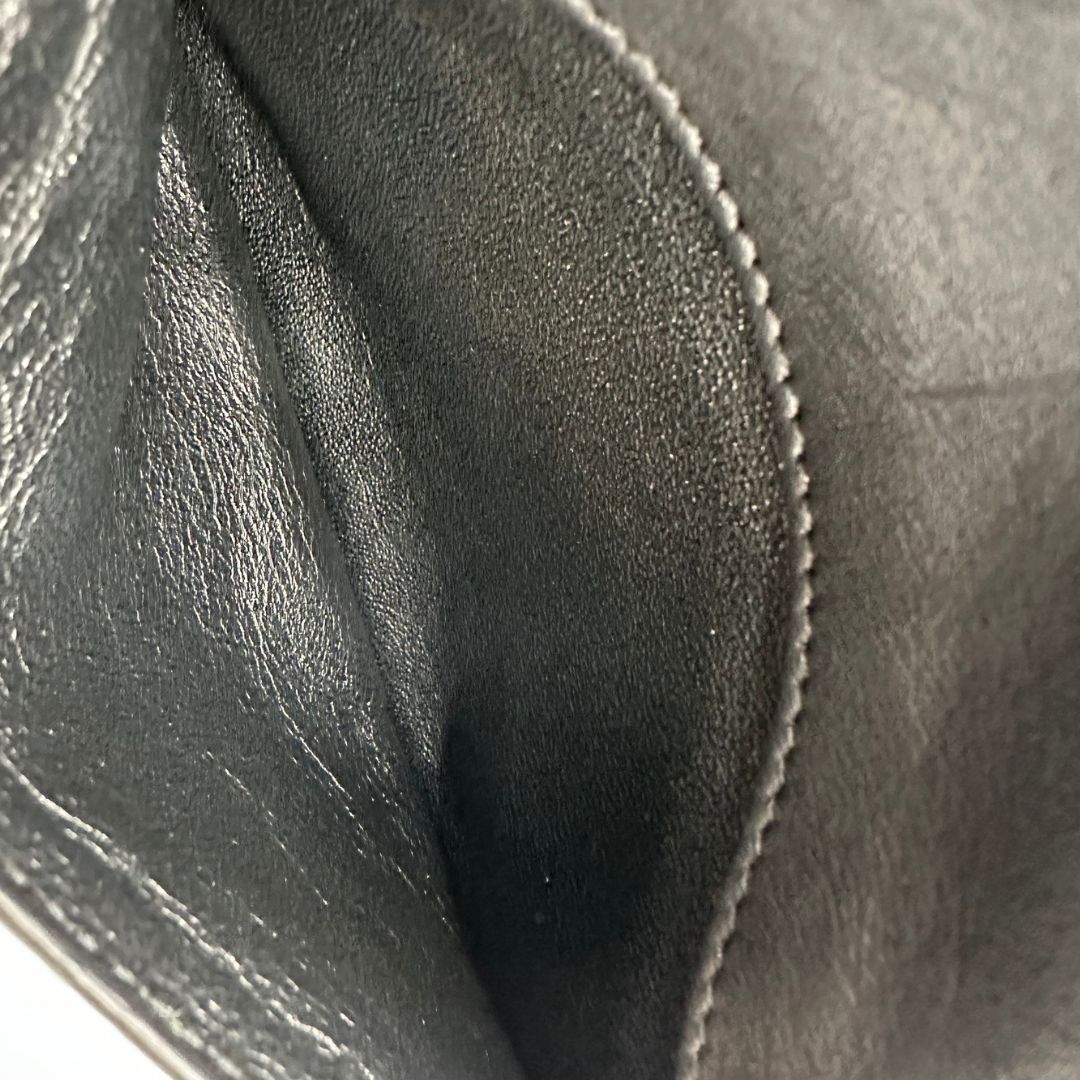 Interno borsa Saint Laurent in pelle nera con iconico logo Cassandre in metallo dorato, di lusso, originale, ottime condizioni, usata. 