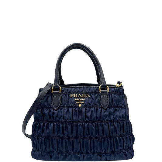 Front di una tote Prada goffrata in tessuto blu notte, dotata di tracolla, usata, originale, second hand, in condizioni eccellenti.