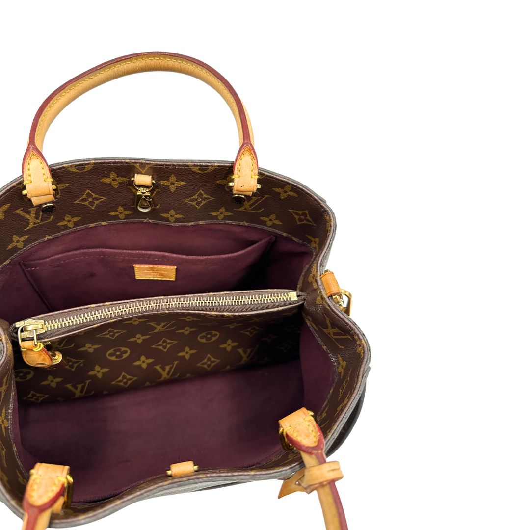 Interno, Borsa Louis Vuitton Montaigne nella versione media in canvas marrone e hardware dorato, indossabile a mano oppure a spalla. Originale, usata, di lusso, in ottime condizioni.