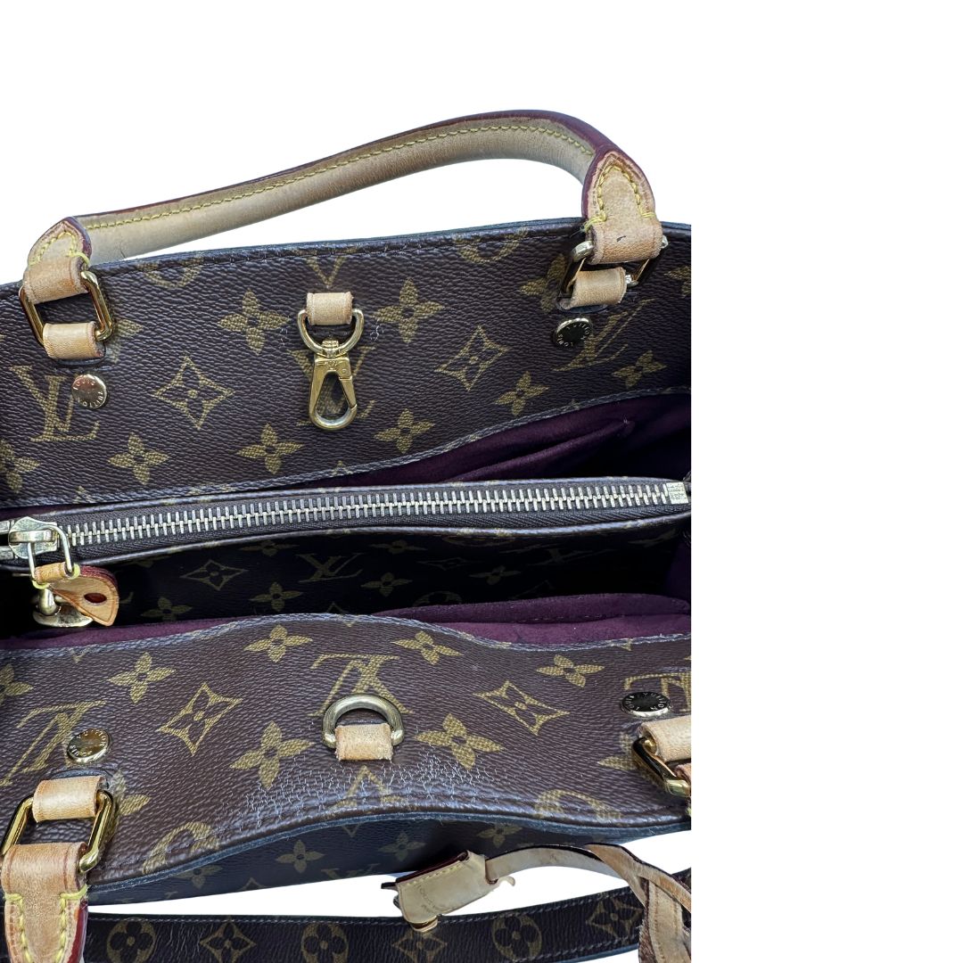 Interno, Borsa Louis Vuitton Montaigne nella versione media in canvas marrone e hardware dorato, indossabile a mano oppure a spalla. Originale, usata, di lusso, in ottime condizioni.