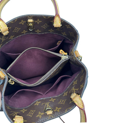 Interno, Borsa Louis Vuitton Montaigne nella versione media in canvas marrone e hardware dorato, indossabile a mano oppure a spalla. Originale, usata, di lusso, in ottime condizioni.
