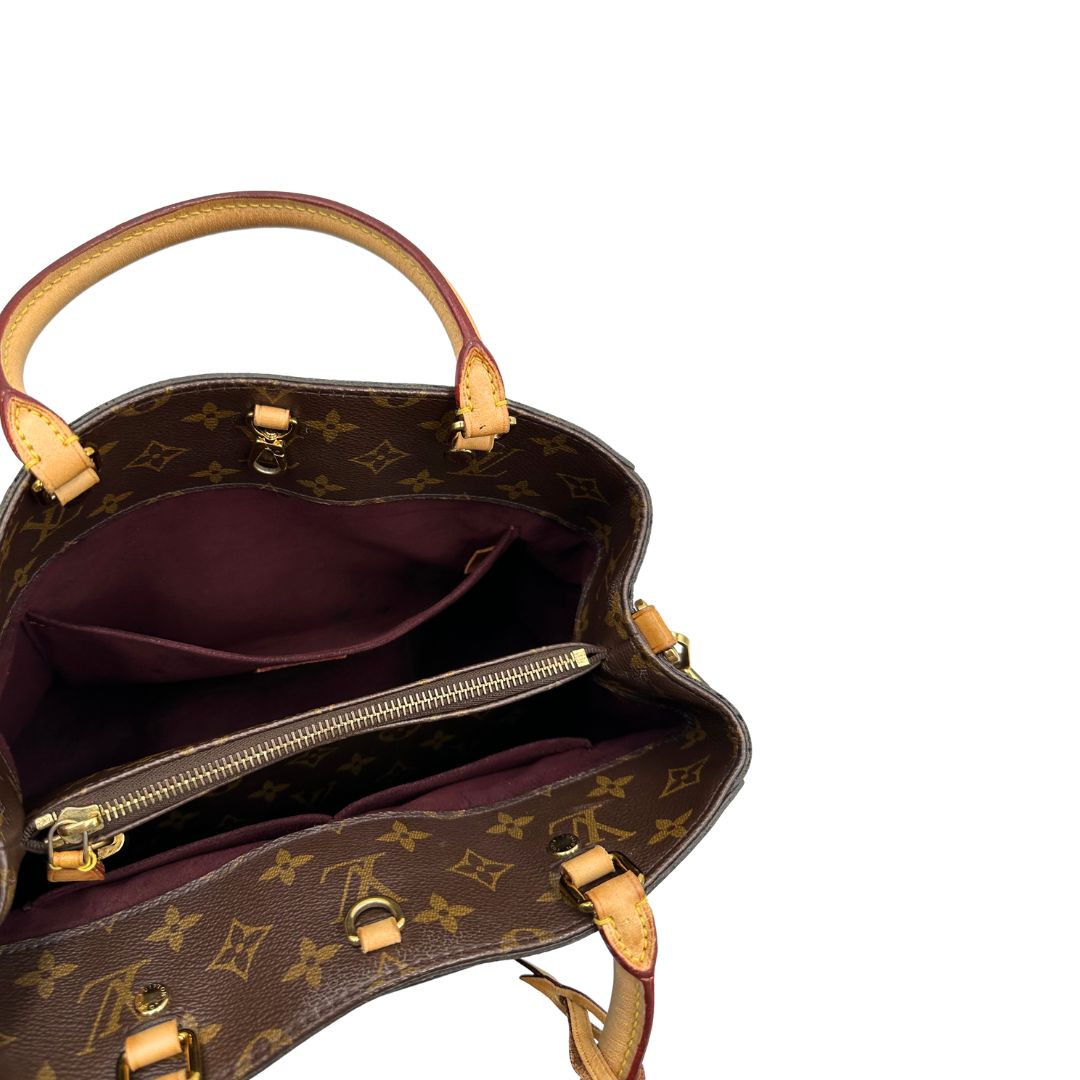 Interno, Borsa Louis Vuitton Montaigne nella versione media in canvas marrone e hardware dorato, indossabile a mano oppure a spalla. Originale, usata, di lusso, in ottime condizioni.