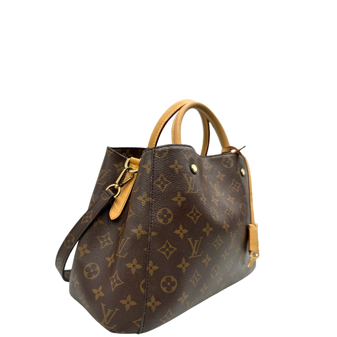 Laterale, Borsa Louis Vuitton Montaigne nella versione media in canvas marrone e hardware dorato, indossabile a mano oppure a spalla. Originale, usata, di lusso, in ottime condizioni.