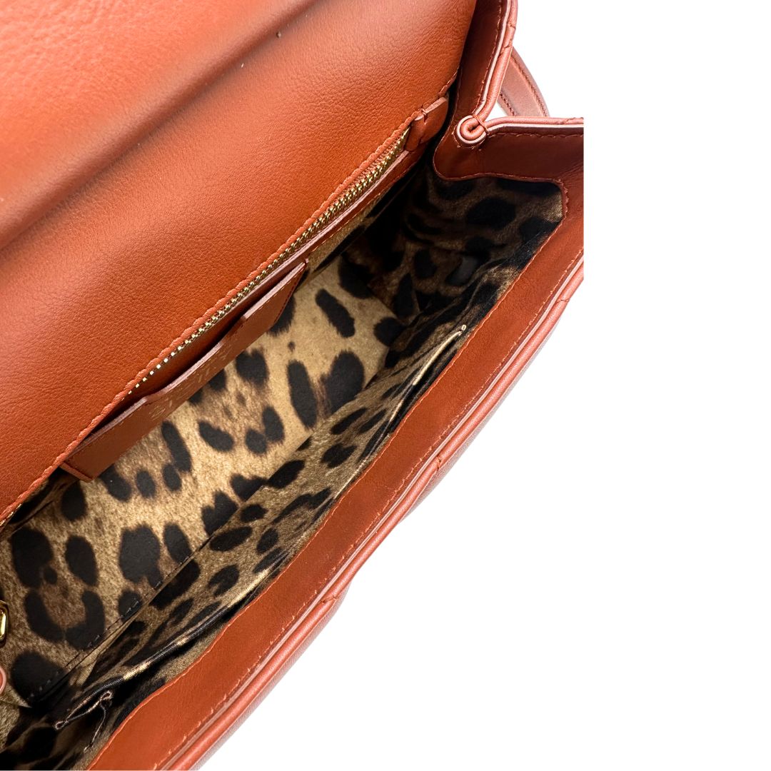 Interno di una borsa D&G in pelle trapuntata color terracotta, e hardware dorato, indossabile a mano oppure a tracolla, usata, originale, second hand, in ottime condizioni.