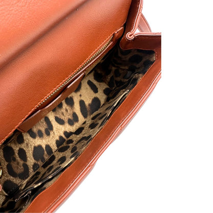 Interno di una borsa D&G in pelle trapuntata color terracotta, e hardware dorato, indossabile a mano oppure a tracolla, usata, originale, second hand, in ottime condizioni.