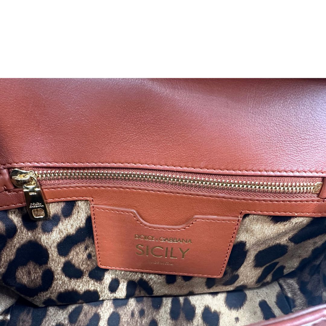 Interno di una borsa D&G in pelle trapuntata color terracotta, e hardware dorato, indossabile a mano oppure a tracolla, usata, originale, second hand, in ottime condizioni.