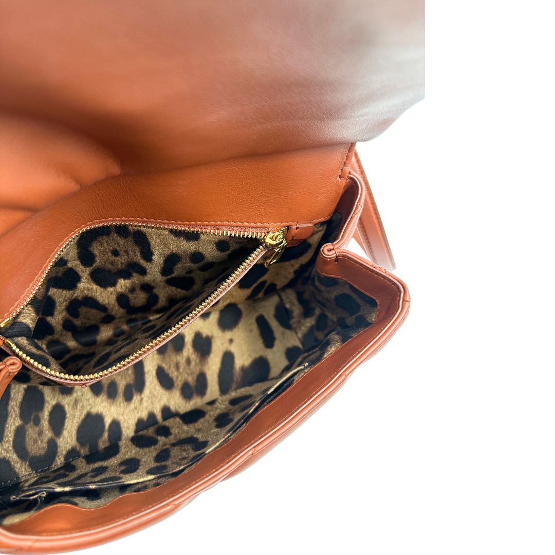 Interno di una borsa D&G in pelle trapuntata color terracotta, e hardware dorato, indossabile a mano oppure a tracolla, usata, originale, second hand, in ottime condizioni.