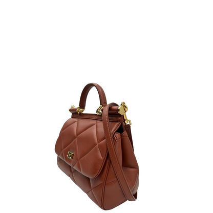 Laterale destro di una borsa D&G in pelle trapuntata color terracotta, e hardware dorato, indossabile a mano oppure a tracolla, usata, originale, second hand, in ottime condizioni.