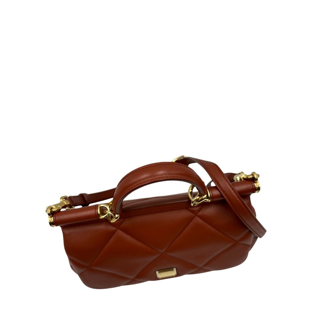 Vista superiore di una borsa D&G in pelle trapuntata color terracotta, e hardware dorato, indossabile a mano oppure a tracolla, usata, originale, second hand, in ottime condizioni.