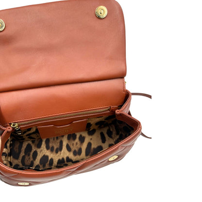 Interno di una borsa D&G in pelle trapuntata color terracotta, e hardware dorato, indossabile a mano oppure a tracolla, usata, originale, second hand, in ottime condizioni.