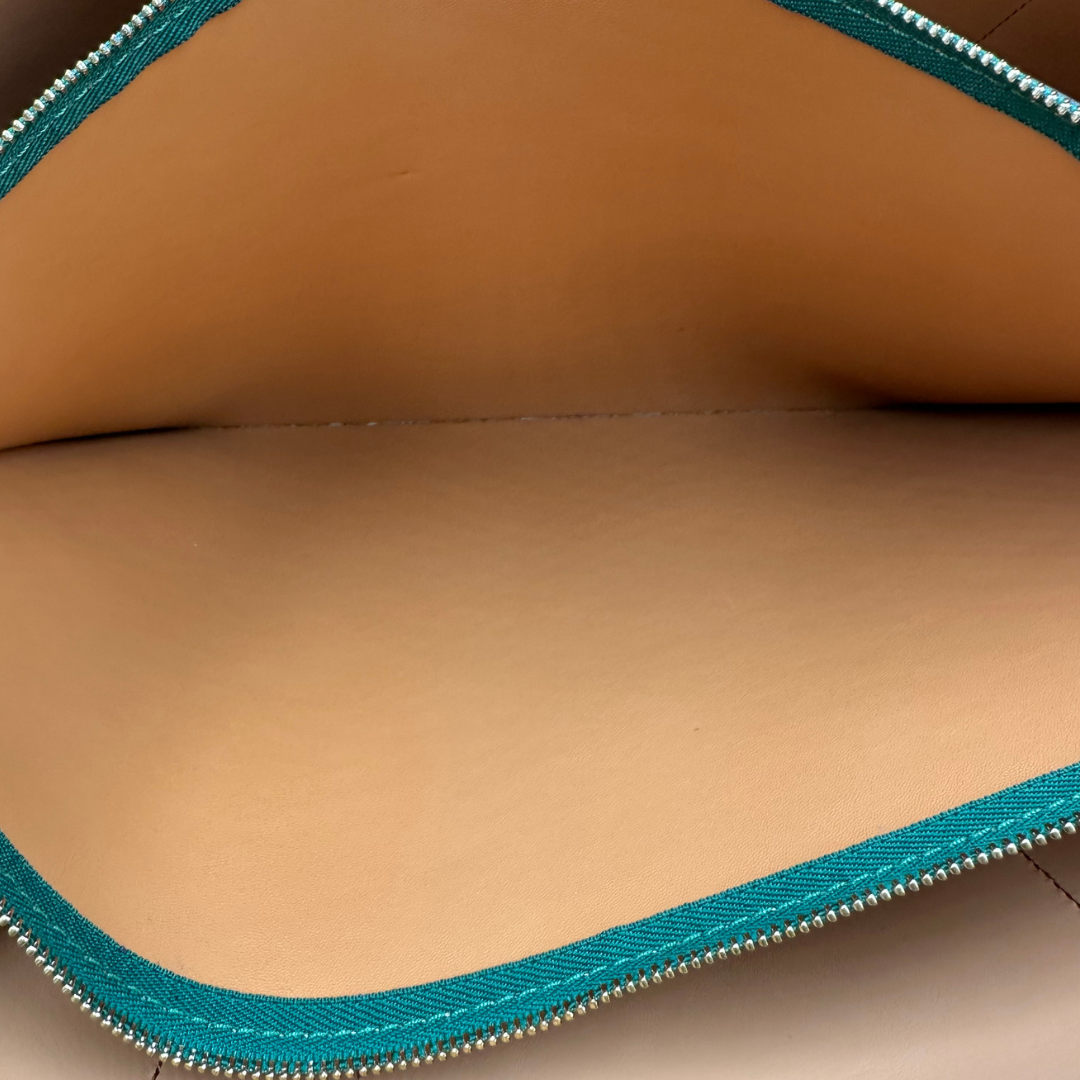 interno  Borsa Tory Burch in pelle martellata verde impreziosita da finiture in tessuto rosa e nero, di lusso, originale, ottime condizioni, usata. 
