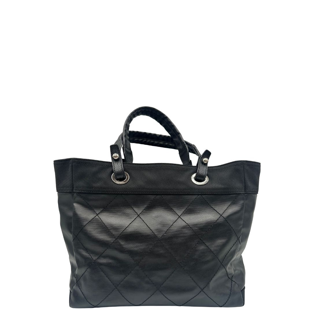 retro Borsa Chanel in pelle nera, caratterizzata da linee morbide ed eleganti. Dotata di doppi manici e charm CC iconico con finiture argentate, di lusso, originale, ottime condizioni, usata. 