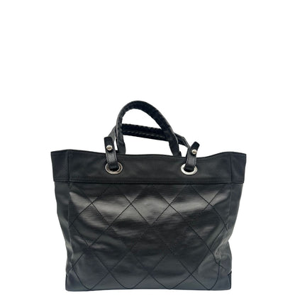 retro Borsa Chanel in pelle nera, caratterizzata da linee morbide ed eleganti. Dotata di doppi manici e charm CC iconico con finiture argentate, di lusso, originale, ottime condizioni, usata. 