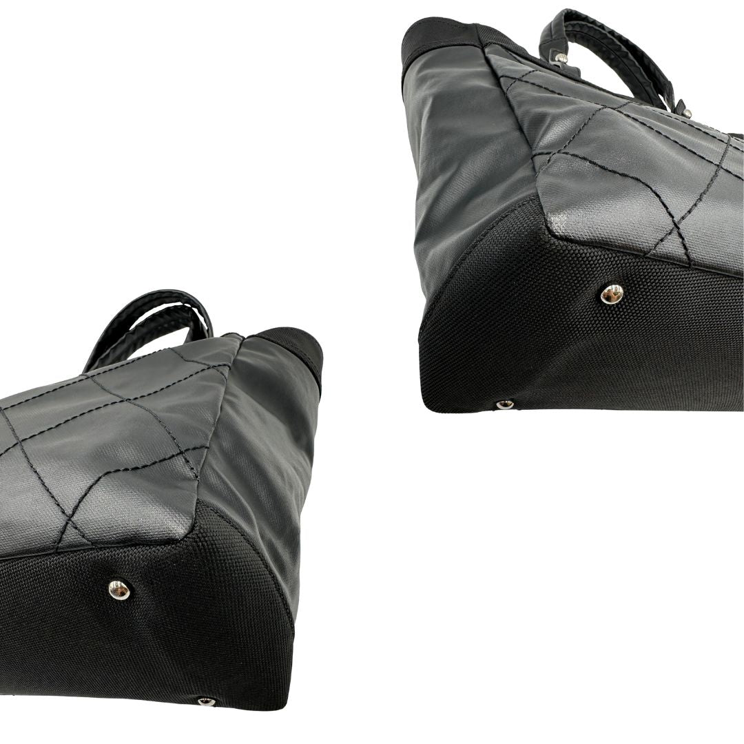 angoli Borsa Chanel in pelle nera, caratterizzata da linee morbide ed eleganti. Dotata di doppi manici e charm CC iconico con finiture argentate, di lusso, originale, ottime condizioni, usata. 