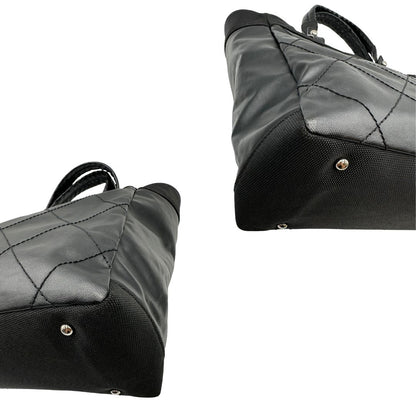 angoli Borsa Chanel in pelle nera, caratterizzata da linee morbide ed eleganti. Dotata di doppi manici e charm CC iconico con finiture argentate, di lusso, originale, ottime condizioni, usata. 