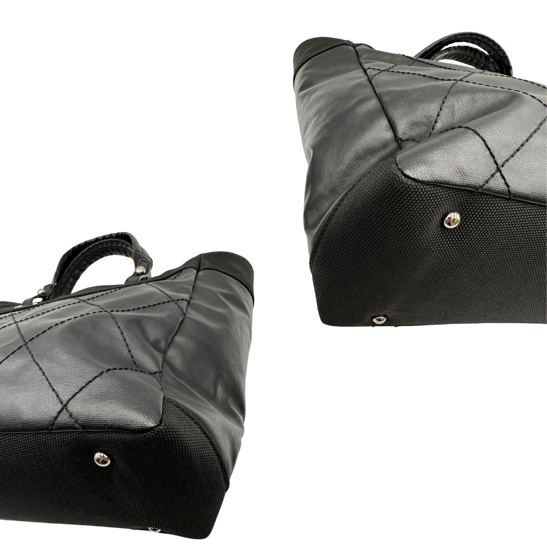 angoli Borsa Chanel in pelle nera, caratterizzata da linee morbide ed eleganti. Dotata di doppi manici e charm CC iconico con finiture argentate, di lusso, originale, ottime condizioni, usata. 