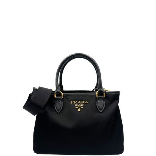 front Borsa Prada in nylon nero con finiture in pelle saffiano tono su tono; munita di doppi manici stondati e una tracolla logata in tessuto regolabile ed amovibile, di lusso, originale, ottime condizioni, usata. 