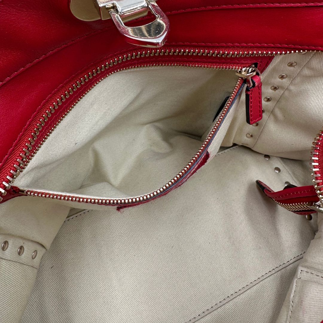 interno Borsa V. G. in pelle rossa impreziosita da borchie piramidali dorate, di lusso, originale, ottime condizioni, usata. 
