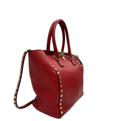 lato Borsa V. G. in pelle rossa impreziosita da borchie piramidali dorate, di lusso, originale, ottime condizioni, usata. 