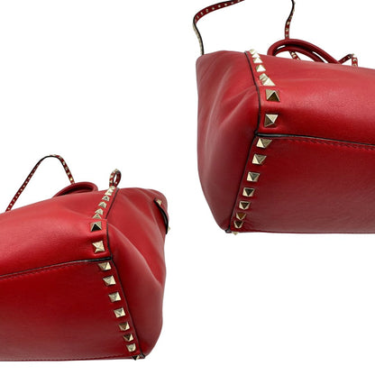 angoli Borsa V. G. in pelle rossa impreziosita da borchie piramidali dorate, di lusso, originale, ottime condizioni, usata. 