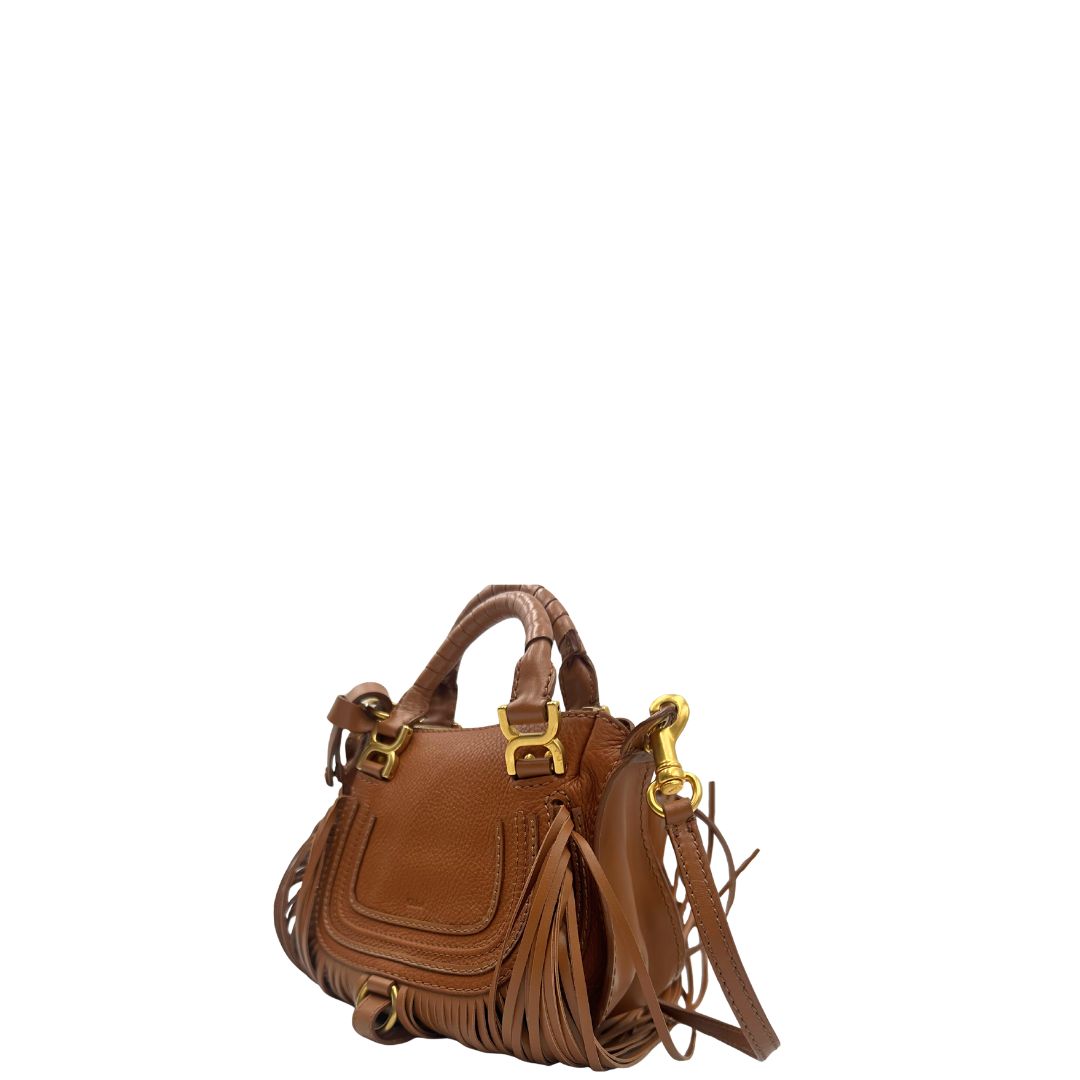 Laterale, Borsa Chloè Marcie in pelle martellata color cammello, caratterizzata da lunghe ed evidenti frange decorative. Indossabile a tracolla oppure a mano. Originale, usata, di lusso, in condizioni eccellenti.