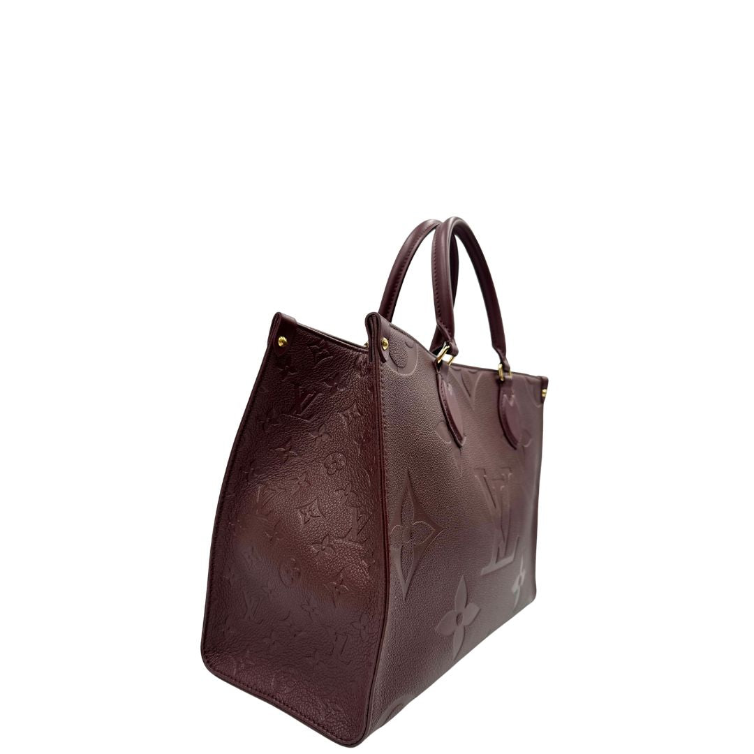 lato  Louis Vuitton OnTheGo nella versione MM in pelle monogram Empreinte color bordeaux, di lusso, originale, ottime condizioni, usata. 