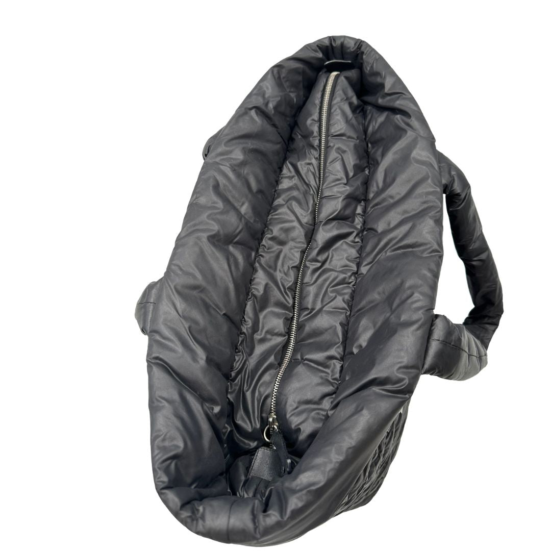 chiusura Chanel in nylon trapuntato nero, caratterizzata da design morbido e leggero con iconico motivo matelassé. Dotata di doppi manici imbottiti, tasca frontale con zip e dettagli argentati, di lusso, originale, ottime condizioni.