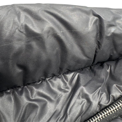 Chanel in nylon trapuntato nero, caratterizzata da design morbido e leggero con iconico motivo matelassé. Dotata di doppi manici imbottiti, tasca frontale con zip e dettagli argentati, di lusso, originale, ottime condizioni.