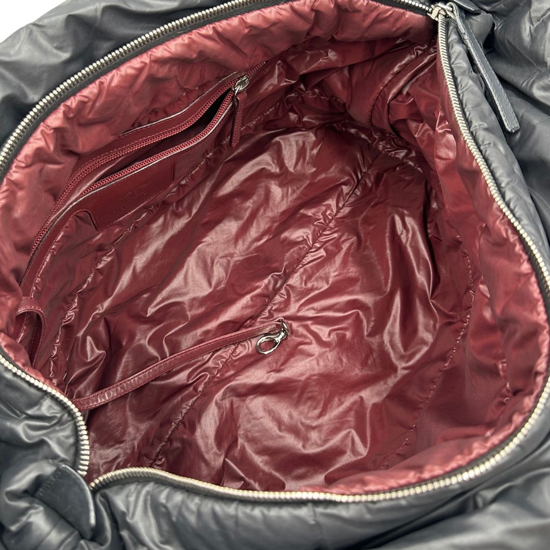 interno Chanel in nylon trapuntato nero, caratterizzata da design morbido e leggero con iconico motivo matelassé. Dotata di doppi manici imbottiti, tasca frontale con zip e dettagli argentati, di lusso, originale, ottime condizioni.