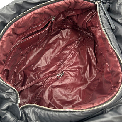 interno Chanel in nylon trapuntato nero, caratterizzata da design morbido e leggero con iconico motivo matelassé. Dotata di doppi manici imbottiti, tasca frontale con zip e dettagli argentati, di lusso, originale, ottime condizioni.