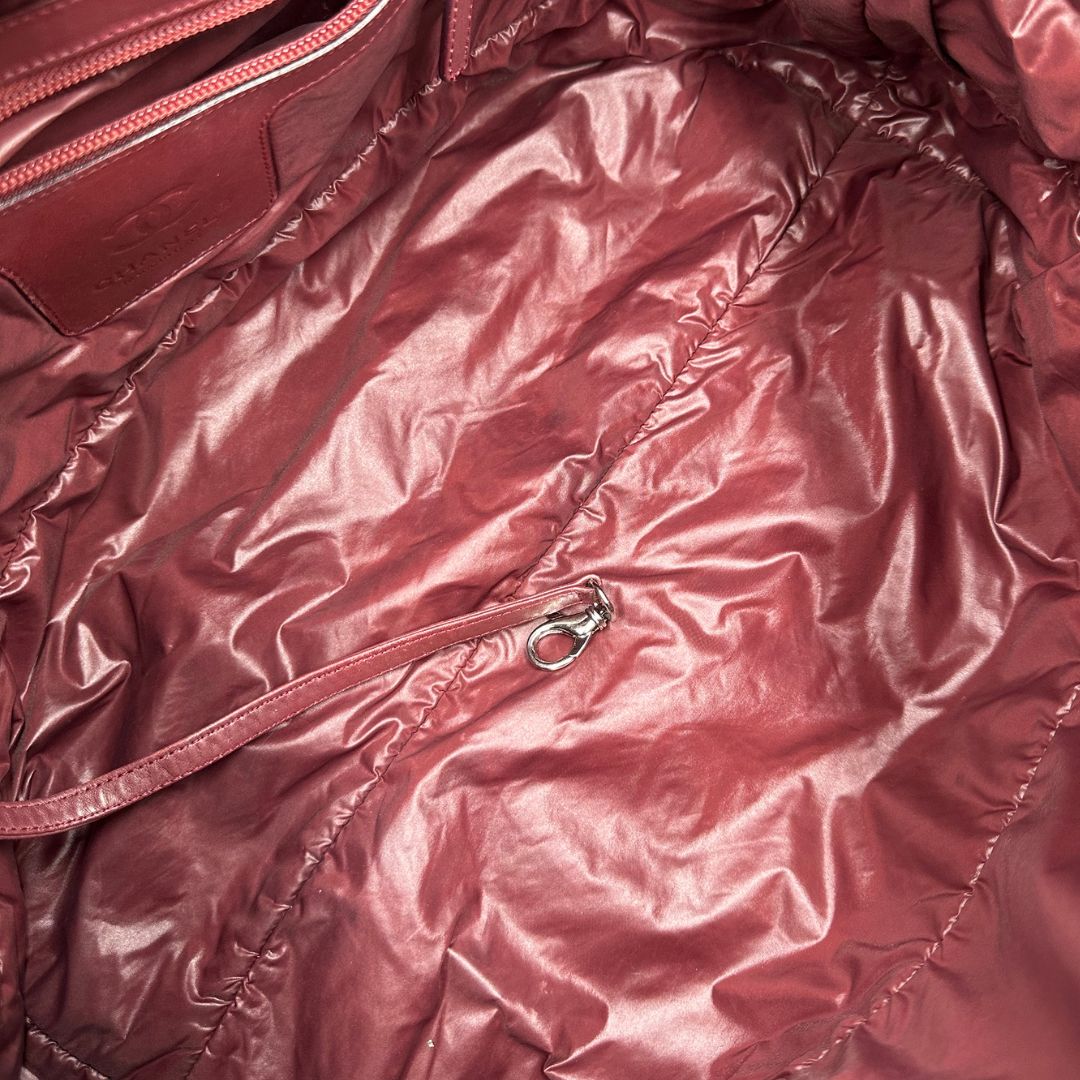 interno Chanel in nylon trapuntato nero, caratterizzata da design morbido e leggero con iconico motivo matelassé. Dotata di doppi manici imbottiti, tasca frontale con zip e dettagli argentati, di lusso, originale, ottime condizioni.