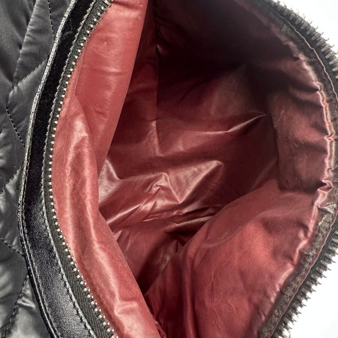 interno Chanel in nylon trapuntato nero, caratterizzata da design morbido e leggero con iconico motivo matelassé. Dotata di doppi manici imbottiti, tasca frontale con zip e dettagli argentati, di lusso, originale, ottime condizioni.