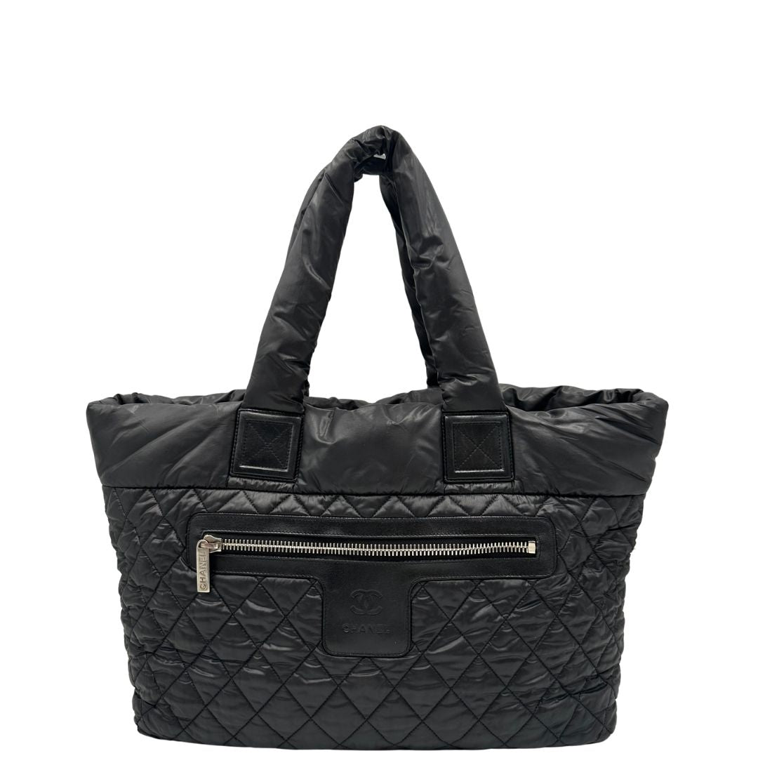 front Chanel in nylon trapuntato nero, caratterizzata da design morbido e leggero con iconico motivo matelassé. Dotata di doppi manici imbottiti, tasca frontale con zip e dettagli argentati, di lusso, originale, ottime condizioni. 