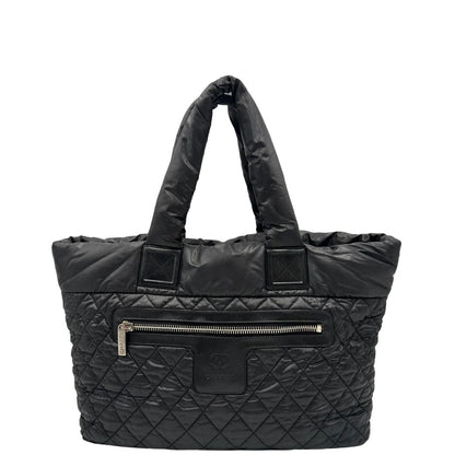 front Chanel in nylon trapuntato nero, caratterizzata da design morbido e leggero con iconico motivo matelassé. Dotata di doppi manici imbottiti, tasca frontale con zip e dettagli argentati, di lusso, originale, ottime condizioni. 