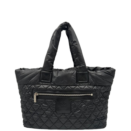 front Chanel in nylon trapuntato nero, caratterizzata da design morbido e leggero con iconico motivo matelassé. Dotata di doppi manici imbottiti, tasca frontale con zip e dettagli argentati, di lusso, originale, ottime condizioni. 