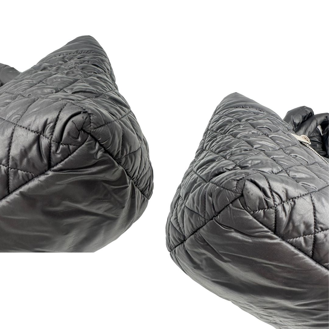 angoli Chanel in nylon trapuntato nero, caratterizzata da design morbido e leggero con iconico motivo matelassé. Dotata di doppi manici imbottiti, tasca frontale con zip e dettagli argentati, di lusso, originale, ottime condizioni. 