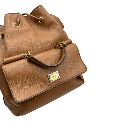 Borsa secchiello Dolce & Gabbana in pelle martellata color cuoio, dal design morbido e sofisticato. Il modello è caratterizzato da chiusura con coulisse, dettagli metallici color oro e silhouette strutturata ma versatile.
