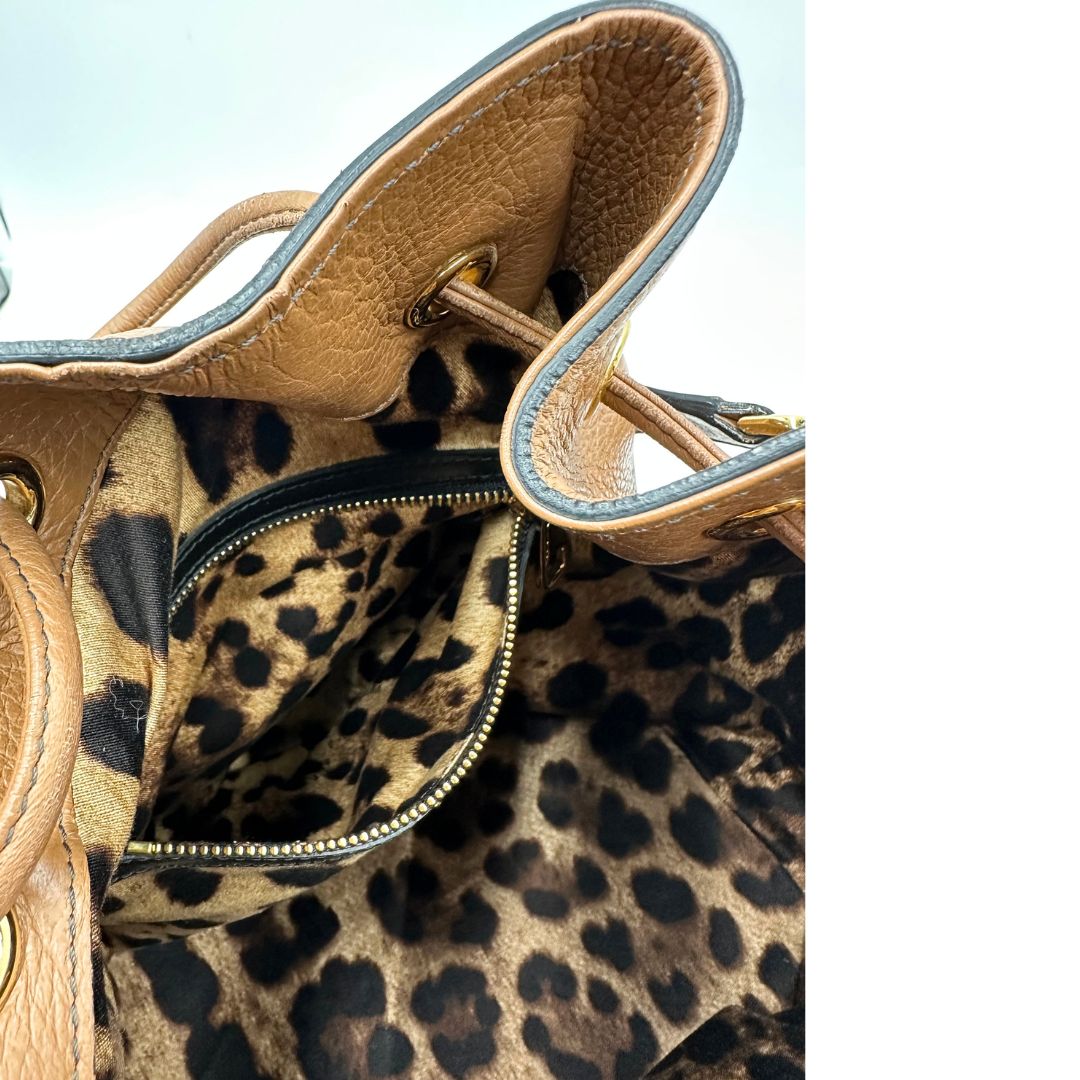 interno Borsa secchiello Dolce & Gabbana in pelle martellata color cuoio, dal design morbido e sofisticato. Il modello è caratterizzato da chiusura con coulisse, dettagli metallici color oro e silhouette strutturata ma versatile. 