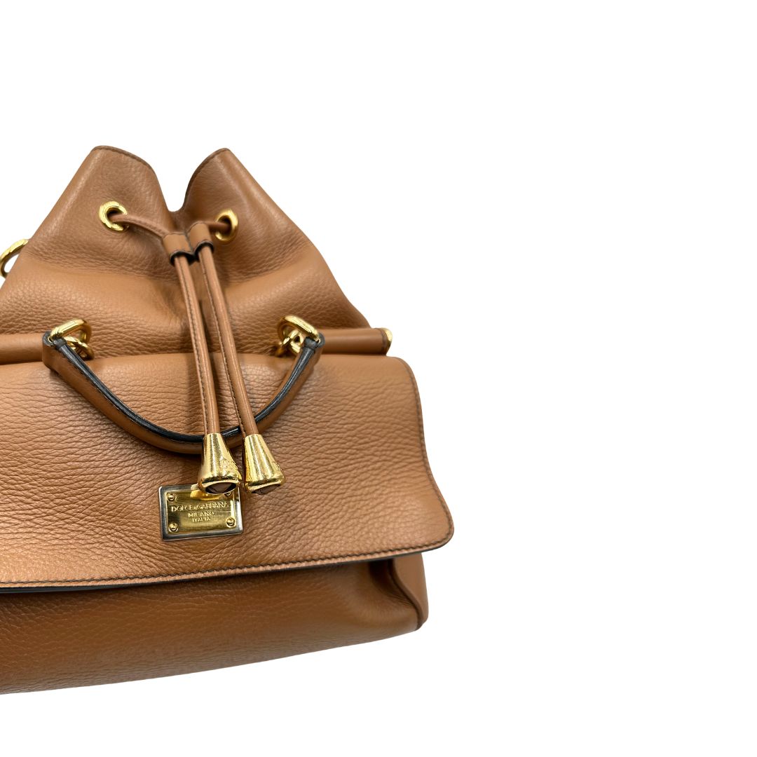Borsa secchiello Dolce & Gabbana in pelle martellata color cuoio, dal design morbido e sofisticato. Il modello è caratterizzato da chiusura con coulisse, dettagli metallici color oro e silhouette strutturata ma versatile.