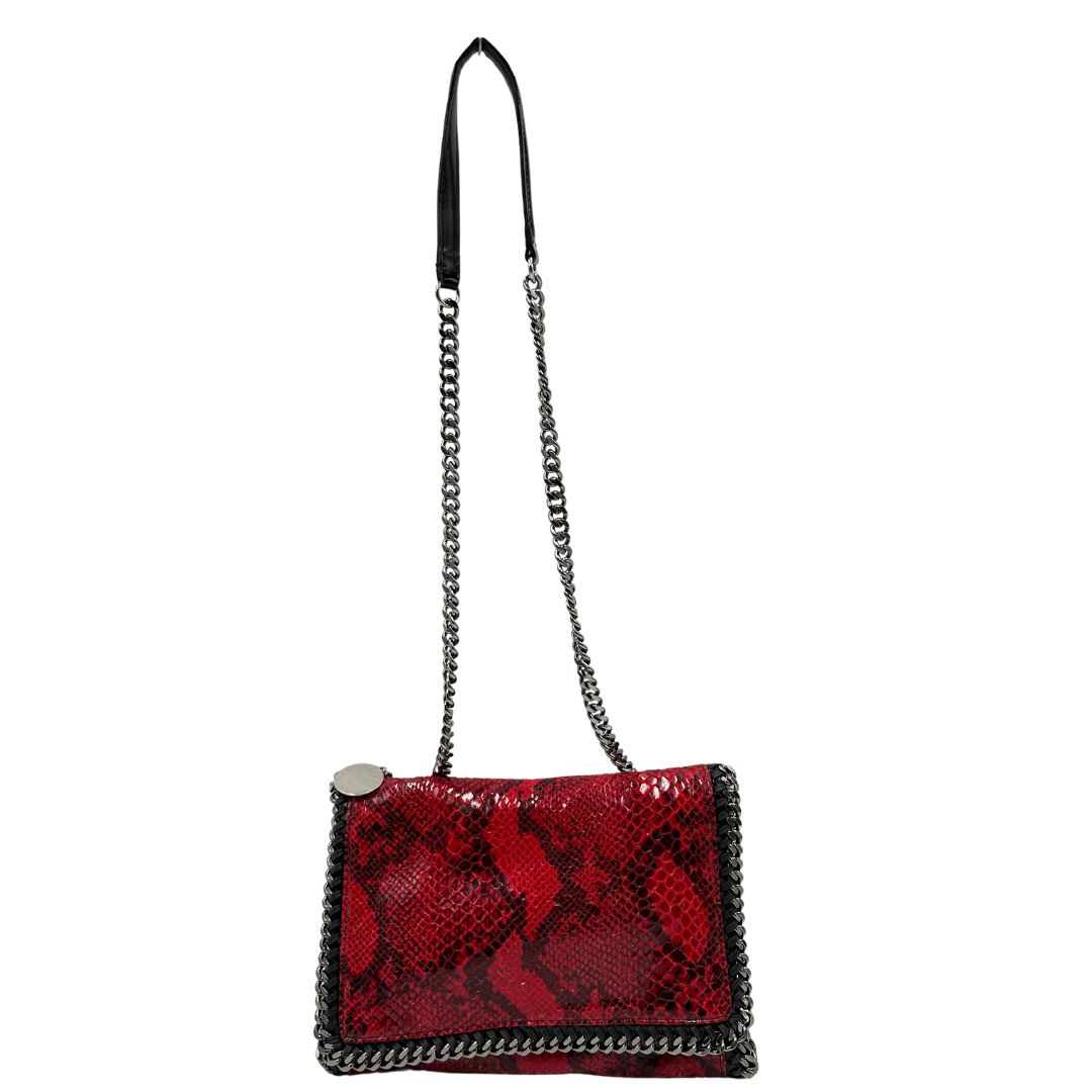 Front, Borsa Stella McCartney, modello compatto e grintoso, realizzata in ecopelle effetto pitone rosso lucido e impreziosita da dettagli con catena metallica nera lungo i bordi. Indossabile a tracolla. Originale, usata, di lusso, in ottime condizioni.