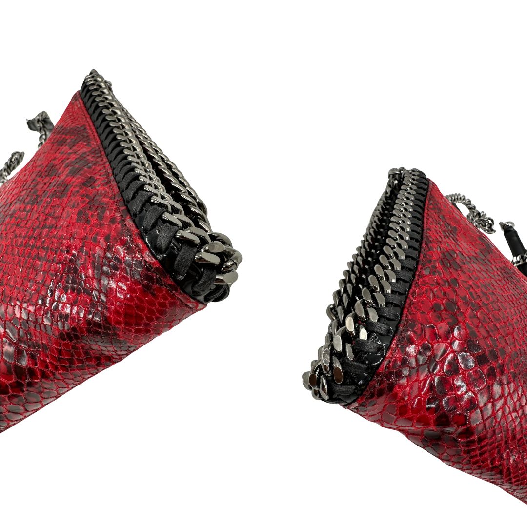 Angoli, Borsa Stella McCartney, modello compatto e grintoso, realizzata in ecopelle effetto pitone rosso lucido e impreziosita da dettagli con catena metallica nera lungo i bordi. Indossabile a tracolla. Originale, usata, di lusso, in ottime condizioni.