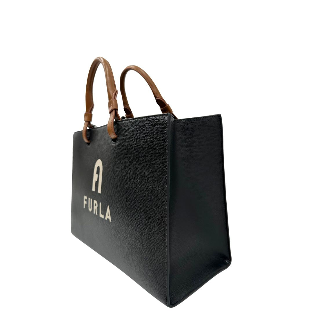 lato Borsa Furla in pelle nera con logo sul front; munita di doppi manici stondati e doppi manici per poterla portare comodamente a spalla, di lusso, originale, eccellenti condizioni. 