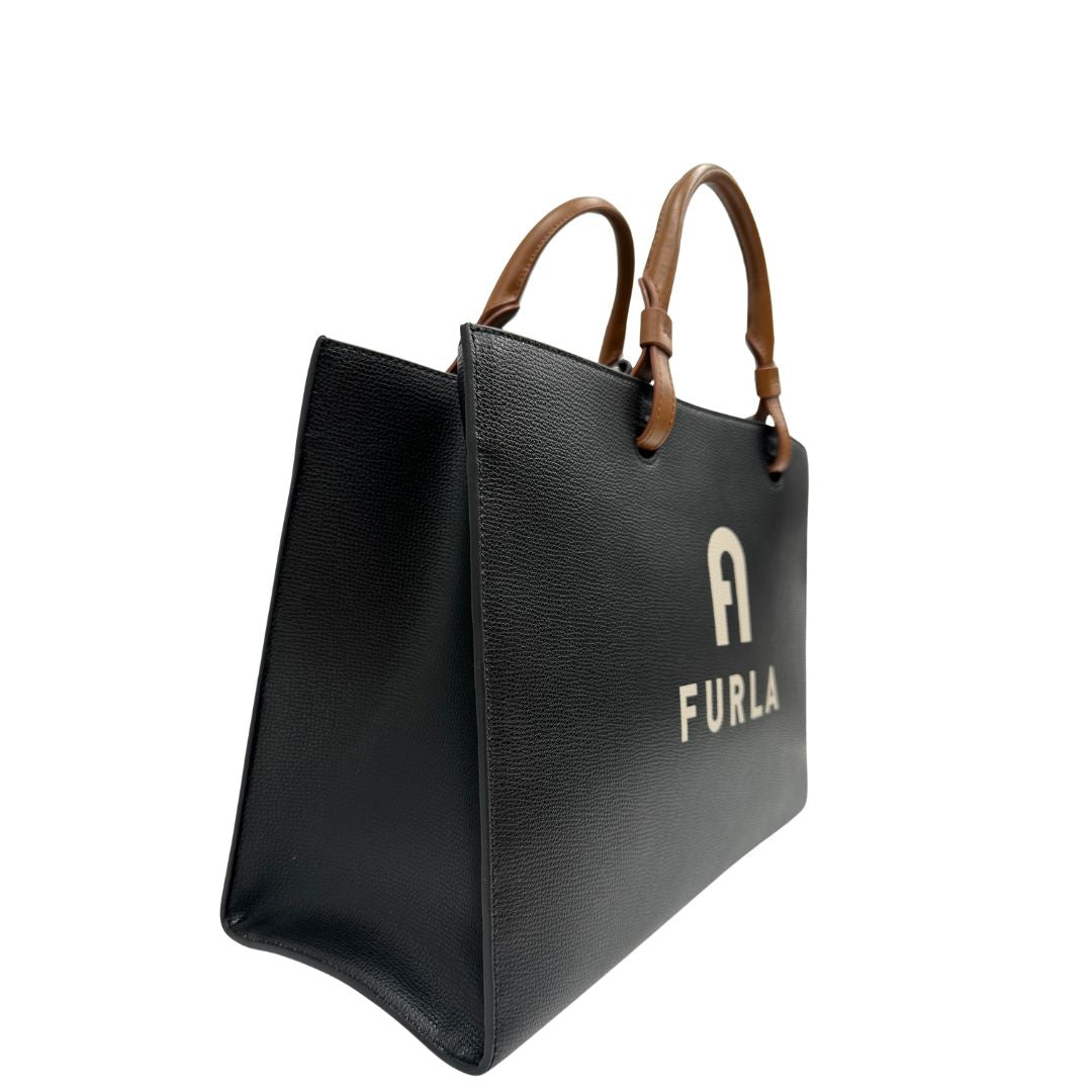 lato Borsa Furla in pelle nera con logo sul front; munita di doppi manici stondati e doppi manici per poterla portare comodamente a spalla, di lusso, originale, eccellenti condizioni. 