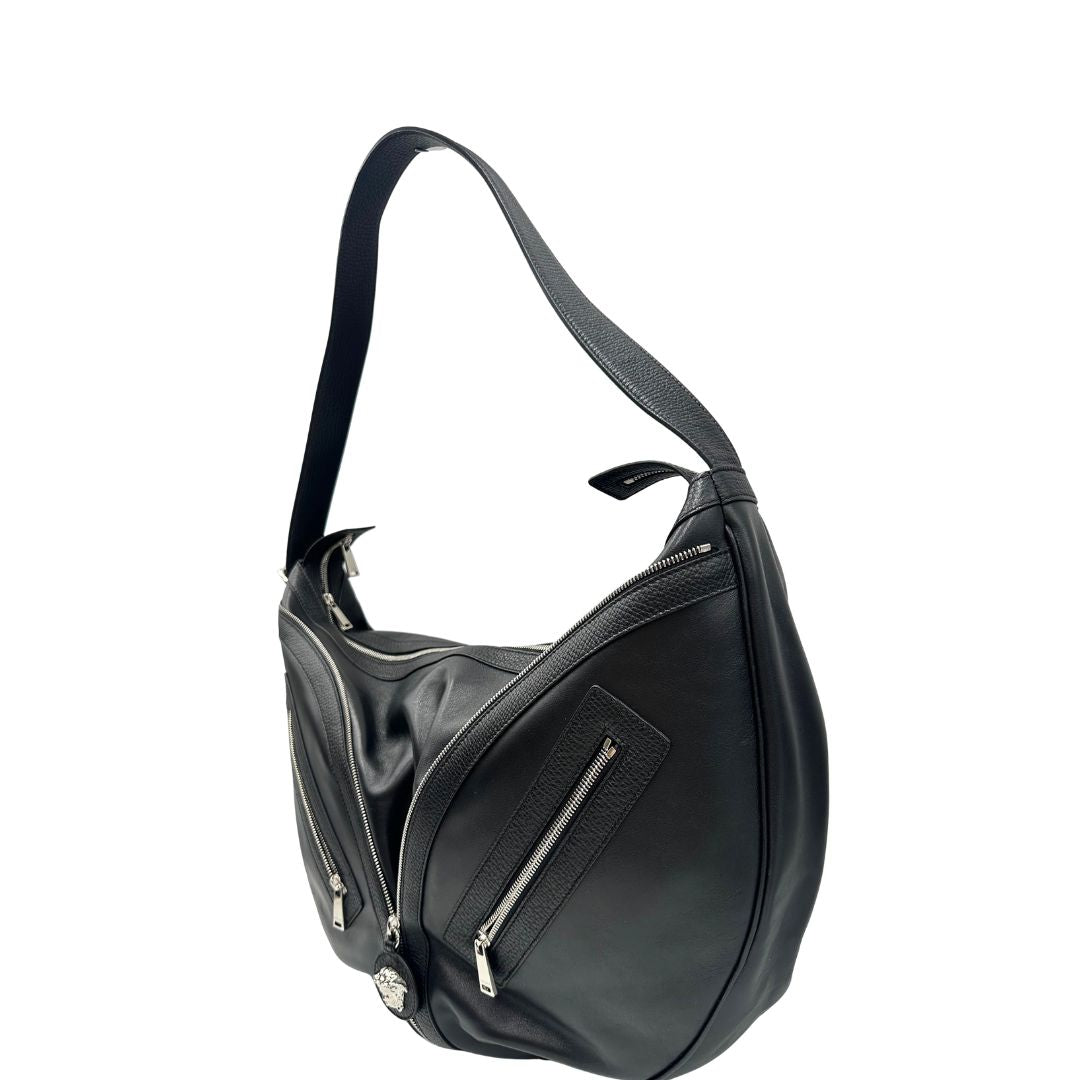 lato  Borsa Versace in pelle nera con hardware argentato, munita di un manico singolo, indossabile a spalla, di lusso, originale, ottime condizioni, usata.
