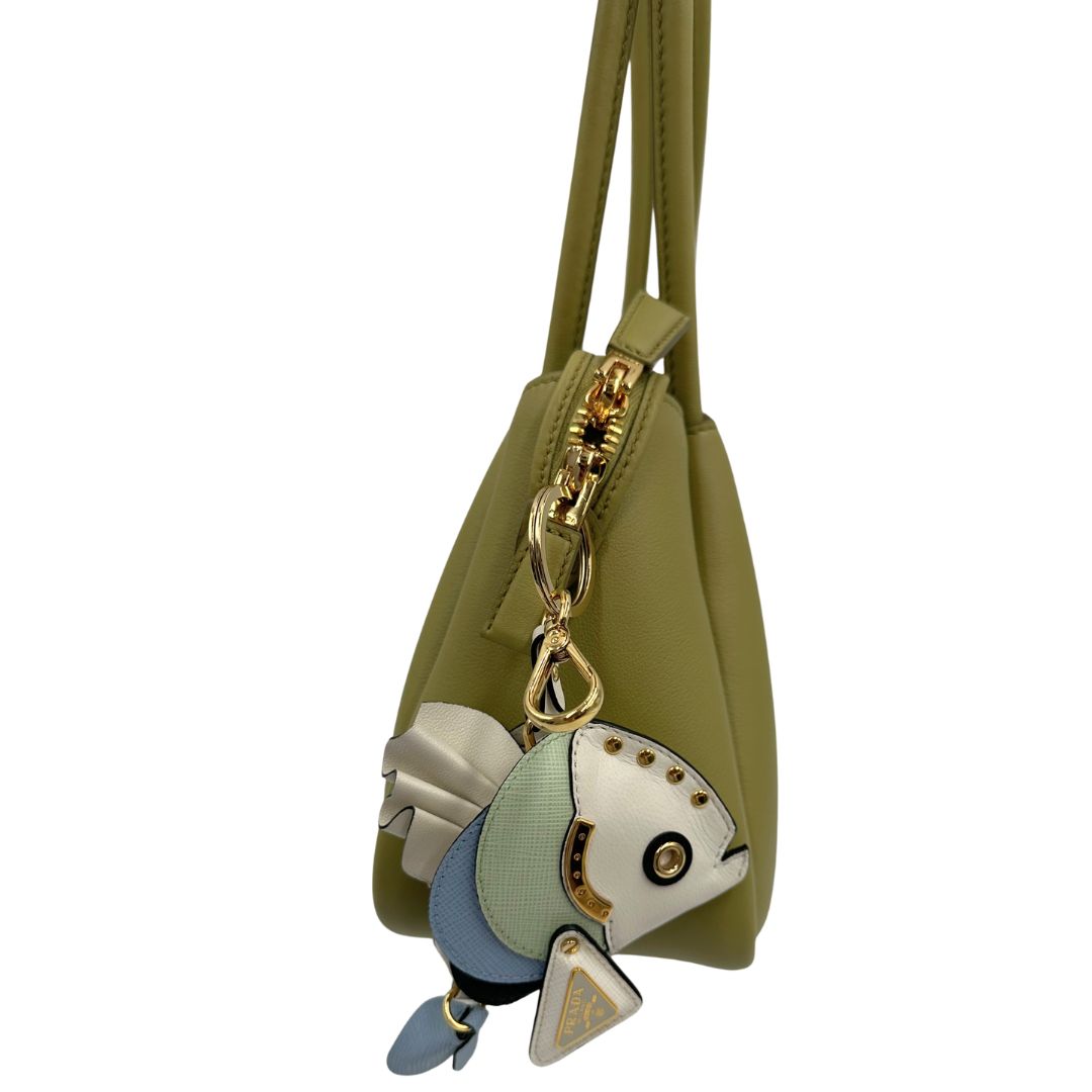 lato Borsa Darling Prada nella versione media color pistacchio impreziosita da harm amovibile e logo triangolo in metallo smaltato, di lusso, originale, eccellenti condizioni.