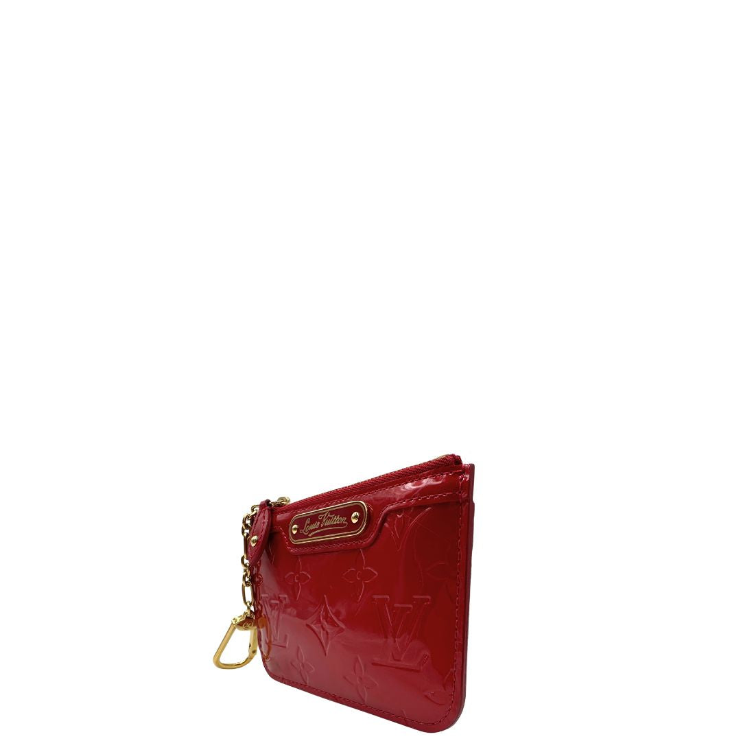 Portamonete Louis Vuitton in pelle vernis rossa con trama monogram empreinte e parti metalliche dorate. Originale, usata, di lusso, in ottime condizioni.