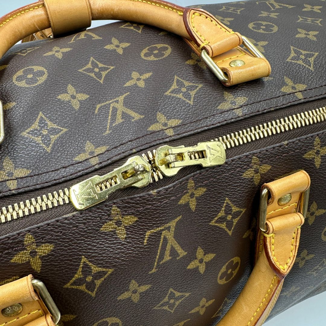 chiusura  Borsone Louis Vuitton Keepall nella misura 60 in canvas marrone monogram e finiture in vacchetta naturale, di lusso, originale, ottime condizioni, usato. 