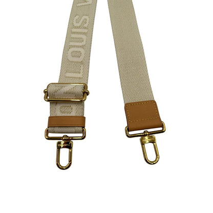 Accessorio tracolla Louis Vuitton realizzato in tessuto beige chiaro con finiture in vacchetta naturale e inserti metallici dorati. Originale, usato, di lusso, in condizioni eccellenti.