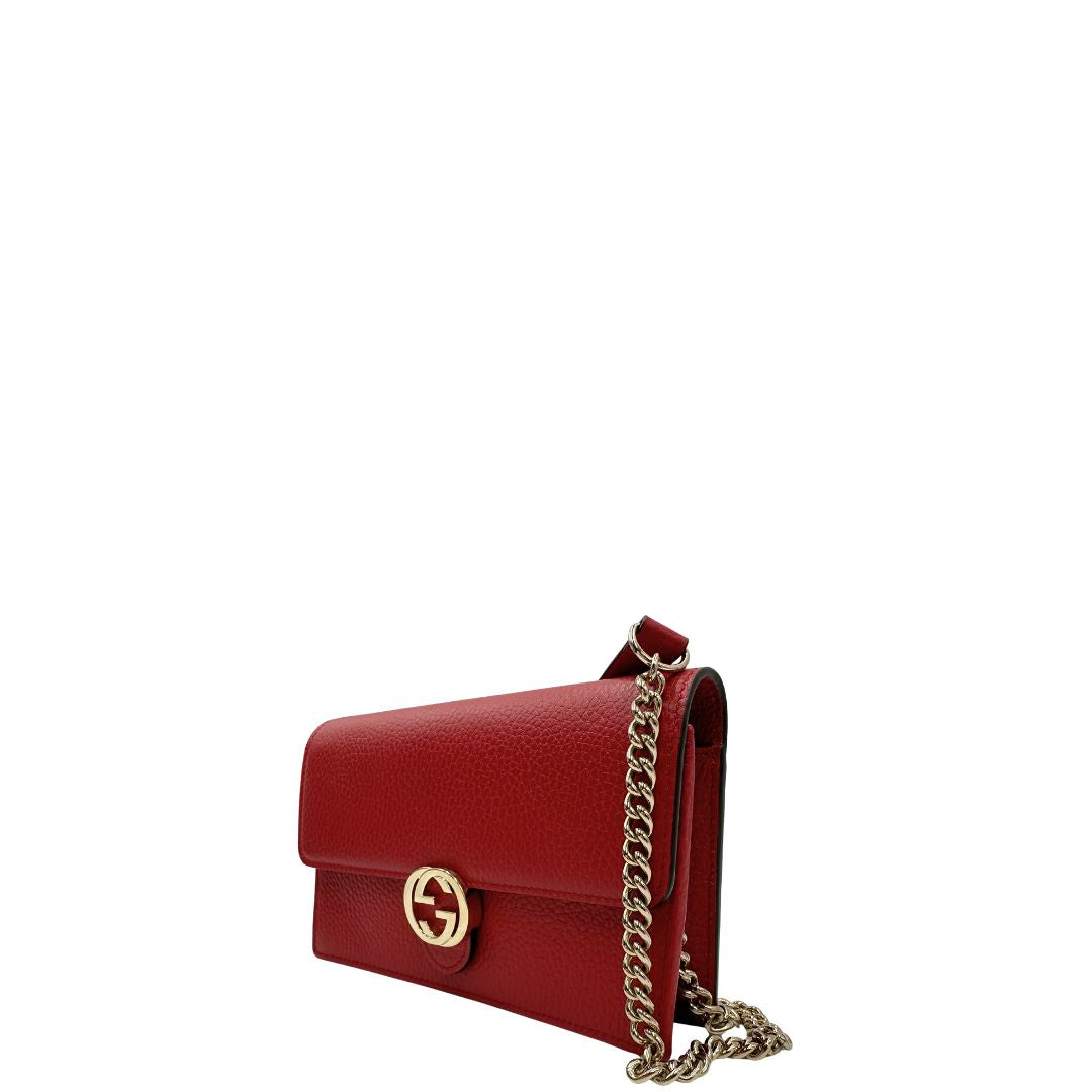 Laterale, Elegante borsa Gucci realizzata in pelle martellata rossa, caratterizzata dall’iconico logo Interlocking dorato. Indossabile a mano oppure a tracolla. Originale, usata, di lusso, in ottime condizioni.